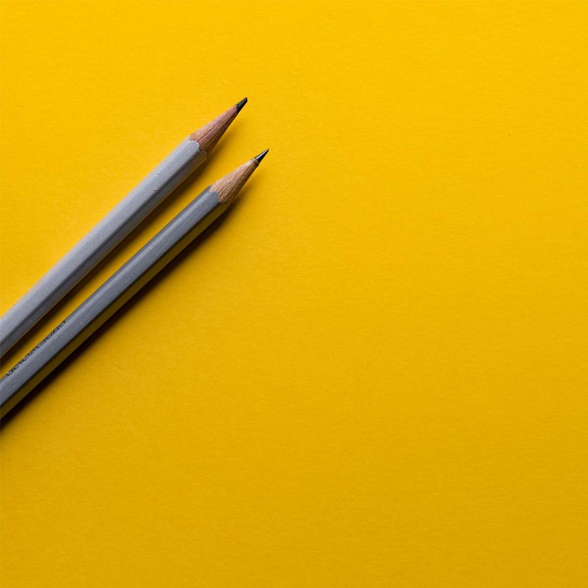 Eine Hand hält einen Stift und markiert Punkte auf einer Notiz im Kästchenformat.