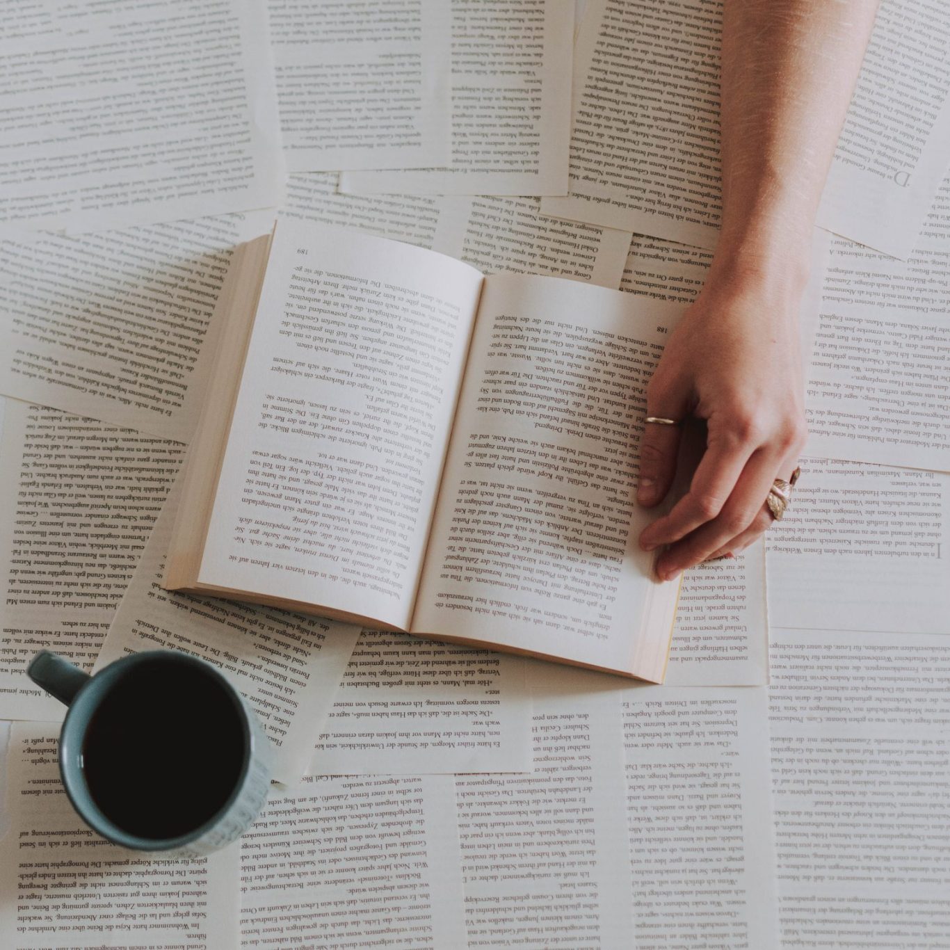 Schwarzer Kaffeebecher mit dem Schriftzug "WEBHERZ", neben Stift und gelbem Notizbuch.